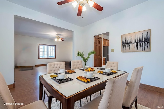 dining space with hardwood / wood-style floors and ceiling fan