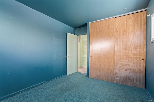 unfurnished bedroom with light colored carpet and a closet