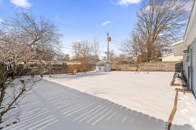 snowy yard featuring a shed