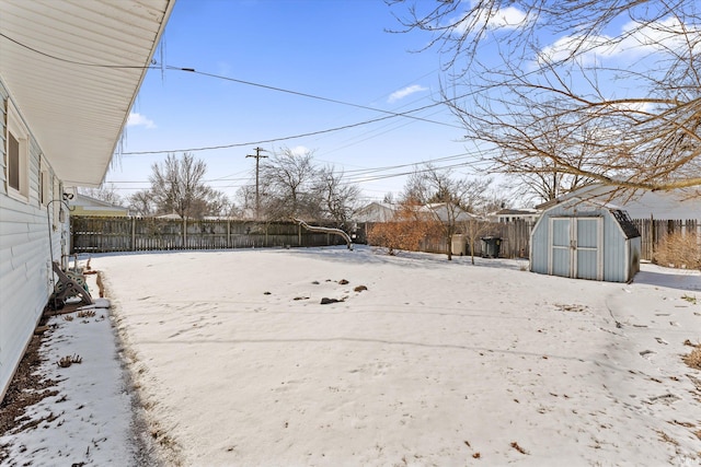 yard layered in snow with a storage unit