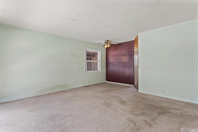 carpeted spare room featuring ceiling fan