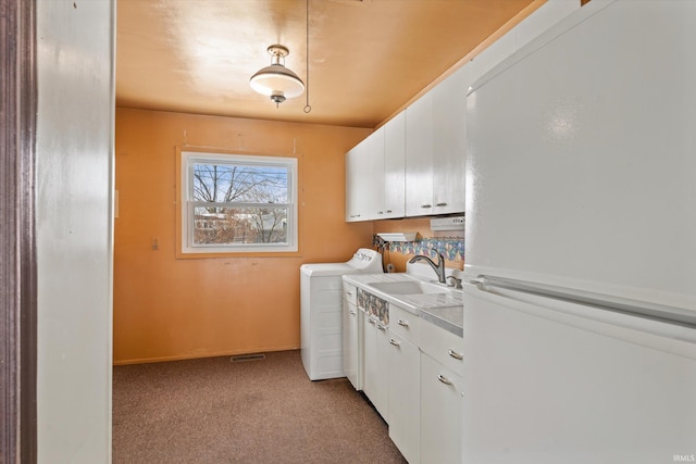 laundry room with light carpet, sink, cabinets, and independent washer and dryer