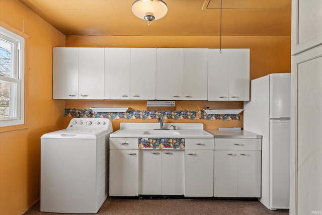 laundry area featuring washer / clothes dryer, plenty of natural light, sink, and cabinets