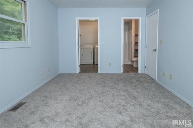 unfurnished bedroom with ensuite bath, washing machine and dryer, and light colored carpet