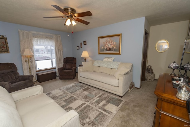 carpeted living room featuring a textured ceiling and ceiling fan