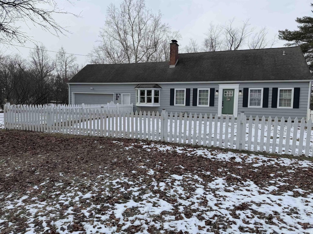 snow covered house with a garage