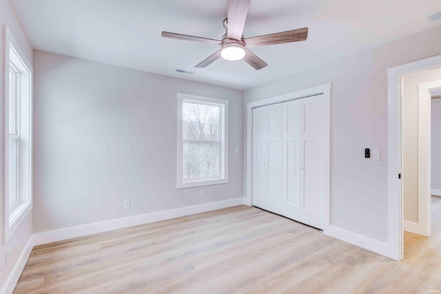 unfurnished bedroom with light hardwood / wood-style flooring, a closet, and ceiling fan