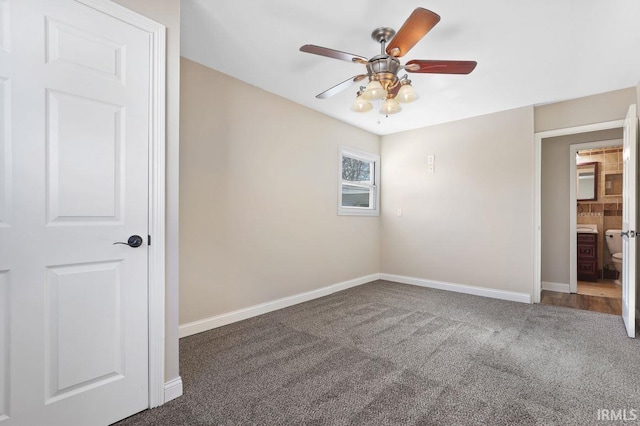 spare room with dark colored carpet and ceiling fan