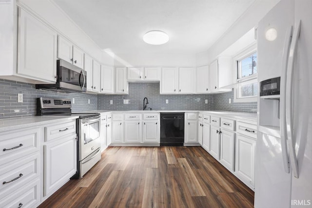 kitchen featuring appliances with stainless steel finishes, tasteful backsplash, white cabinetry, sink, and dark hardwood / wood-style flooring