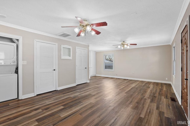 unfurnished living room featuring crown molding, dark wood-type flooring, a textured ceiling, and stacked washer / dryer