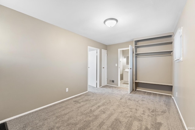 unfurnished bedroom with light colored carpet and a closet