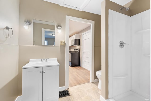 bathroom with vanity, walk in shower, and toilet