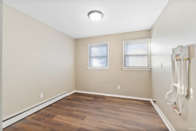 empty room featuring baseboard heating and dark hardwood / wood-style flooring