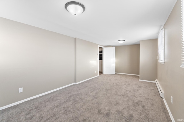 empty room with a baseboard heating unit and carpet floors