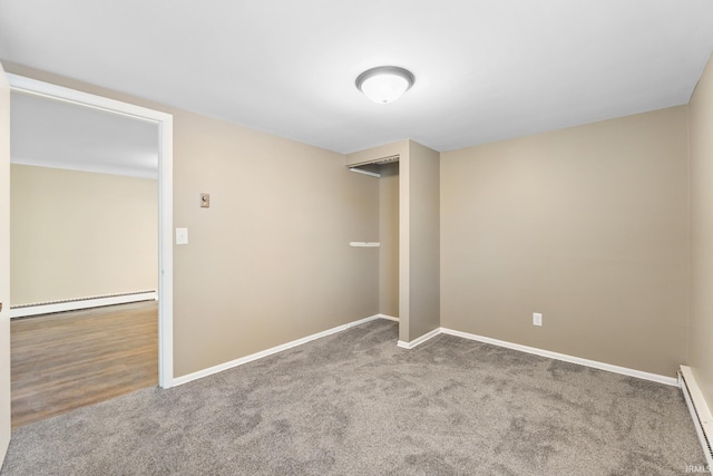 carpeted empty room with baseboard heating