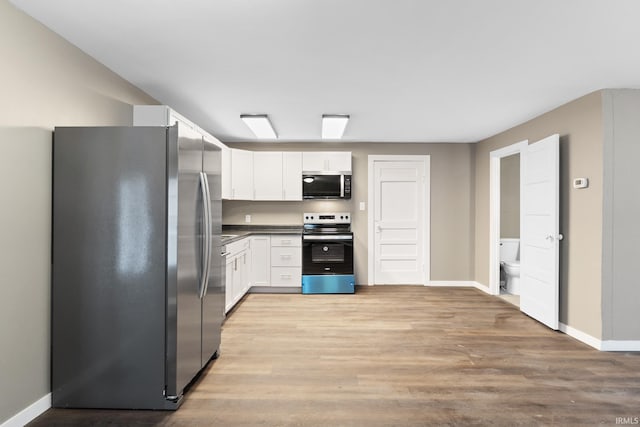 kitchen with stainless steel appliances, light hardwood / wood-style floors, and white cabinets