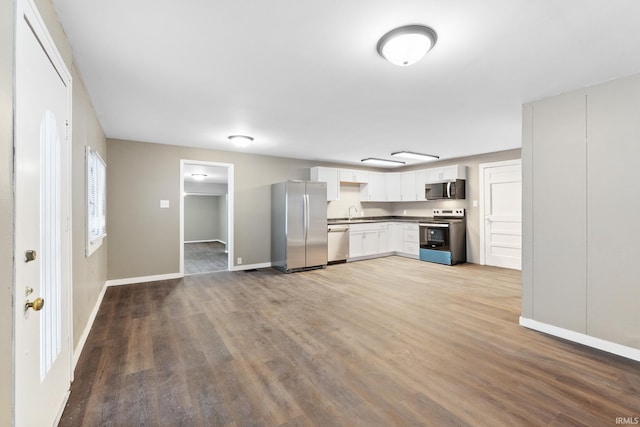 kitchen with appliances with stainless steel finishes, light wood-type flooring, and white cabinets