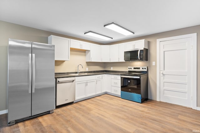 kitchen featuring sink, stainless steel appliances, light hardwood / wood-style floors, and white cabinets