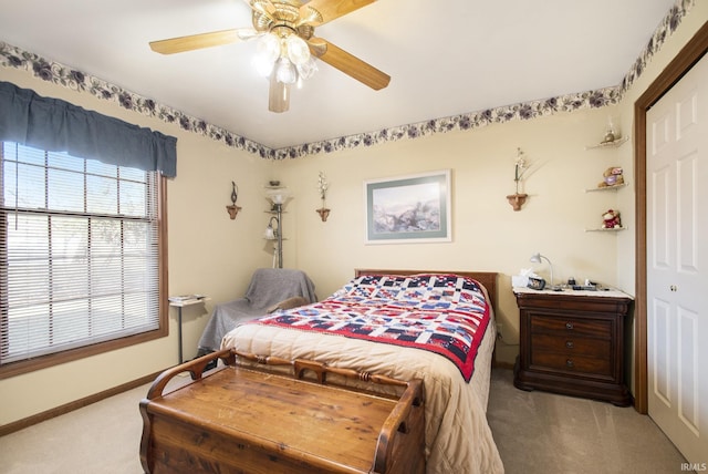 carpeted bedroom with ceiling fan and a closet