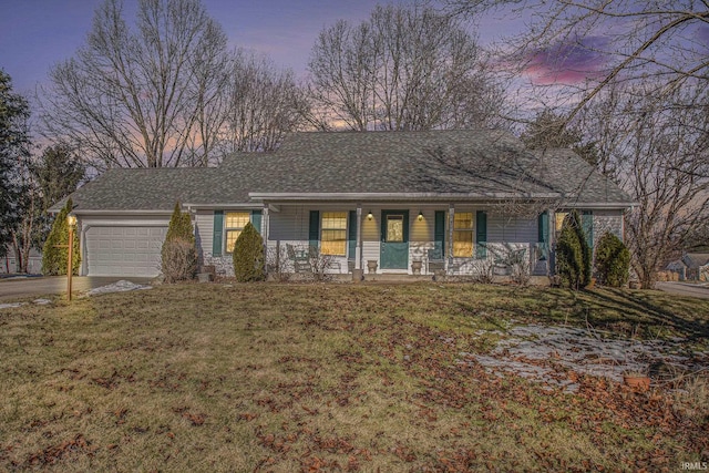 ranch-style home featuring a porch, a garage, and a lawn