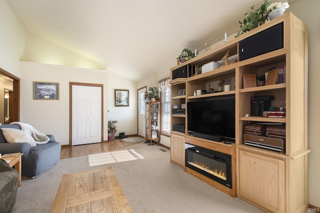 living room with light colored carpet and vaulted ceiling