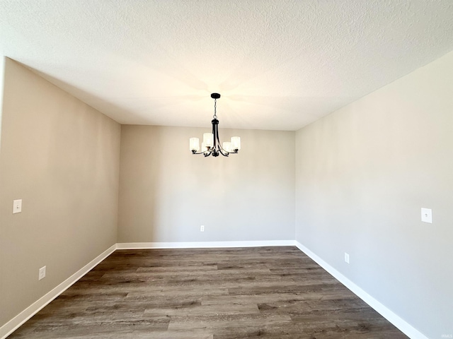 2360 Serenity Ct, Auburn, IN 46706 - spare room featuring a chandelier, dark wood-style flooring, baseboards, and a textured ceiling