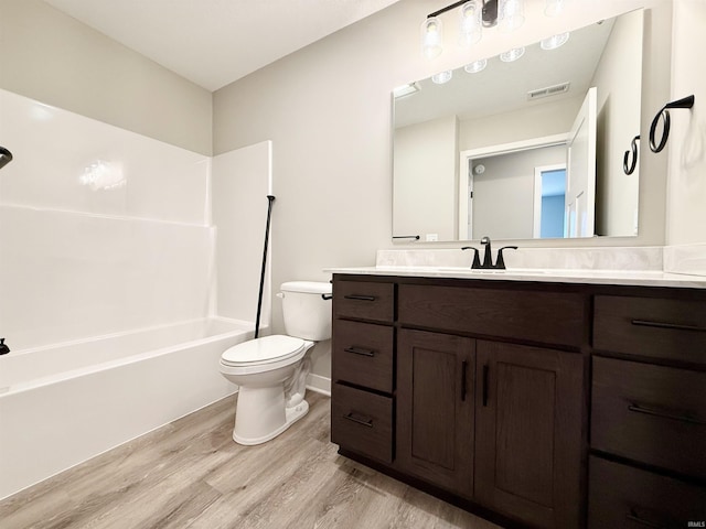 2360 Serenity Ct, Auburn, IN 46706 - bathroom featuring wood finished floors, toilet, vanity, shower / washtub combination, and baseboards