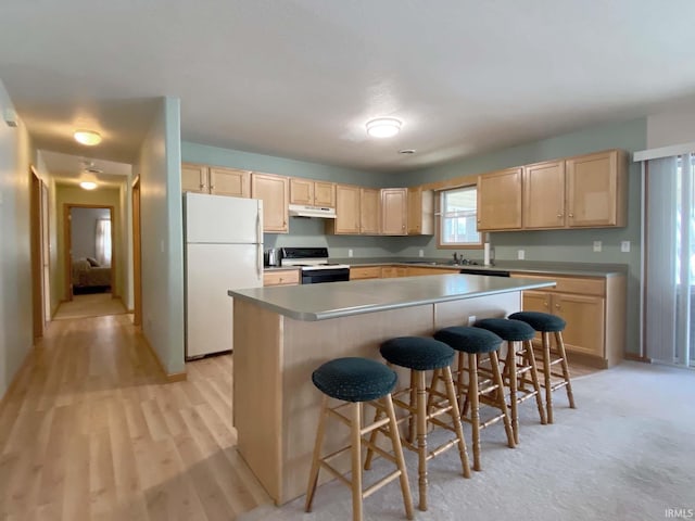 kitchen featuring a kitchen island, range with electric cooktop, a breakfast bar, and white refrigerator