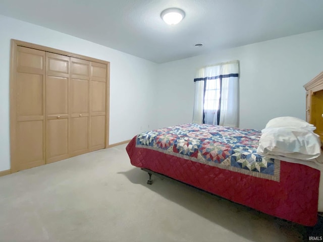 bedroom with light carpet and a closet