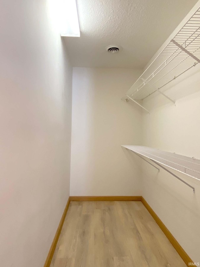 spacious closet with light hardwood / wood-style flooring