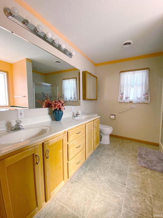 bathroom featuring walk in shower, vanity, toilet, and a wealth of natural light