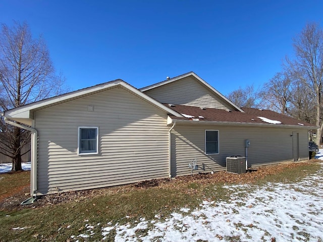 view of snow covered exterior with central AC