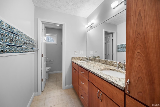 bathroom with vanity, tile patterned floors, a textured ceiling, and toilet