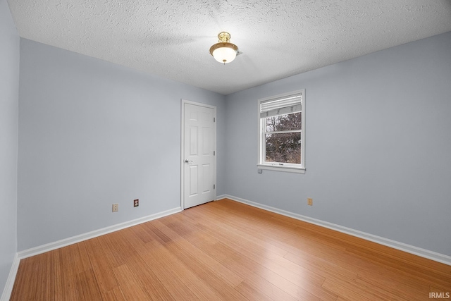 spare room with hardwood / wood-style flooring and a textured ceiling