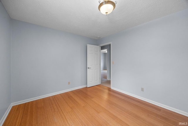 empty room featuring a textured ceiling and light wood-type flooring