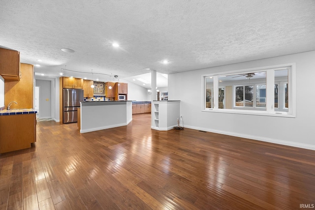 unfurnished living room featuring dark wood-type flooring and a textured ceiling