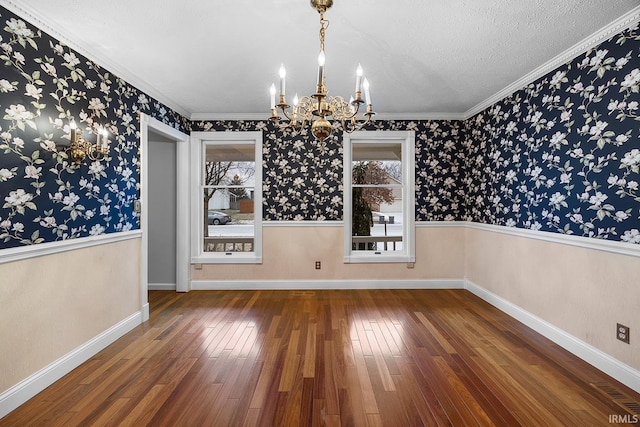 unfurnished dining area with a textured ceiling, ornamental molding, dark hardwood / wood-style floors, and a chandelier