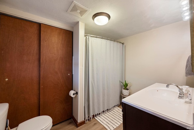 bathroom with vanity, hardwood / wood-style flooring, and toilet