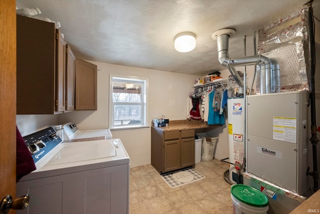 laundry area with cabinets, separate washer and dryer, a textured ceiling, and gas water heater