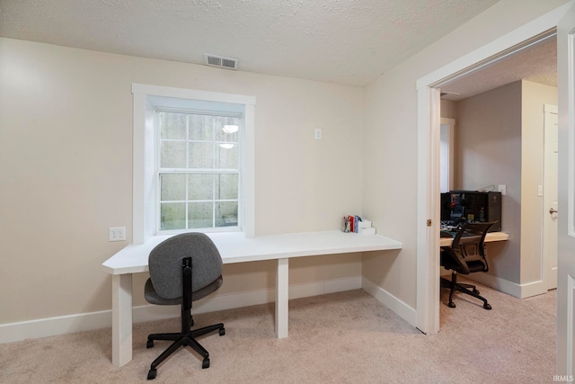 home office featuring light colored carpet and a textured ceiling