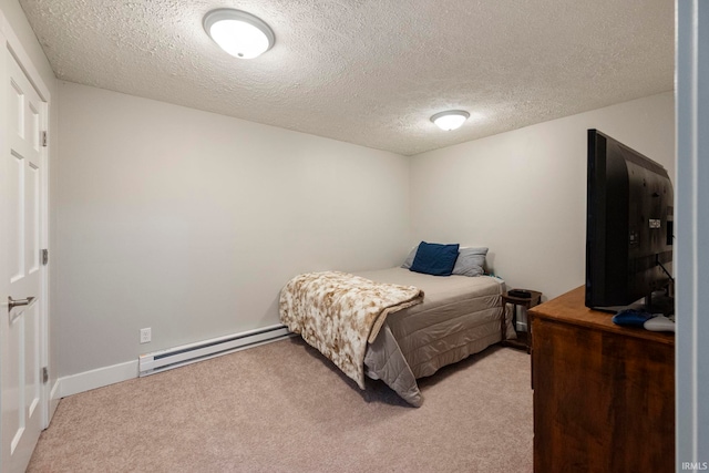 carpeted bedroom featuring a baseboard heating unit and a textured ceiling