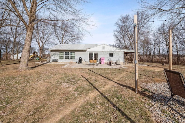 rear view of house with a patio area, a playground, and a lawn