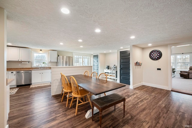 dining room featuring sink, a textured ceiling, and dark hardwood / wood-style flooring