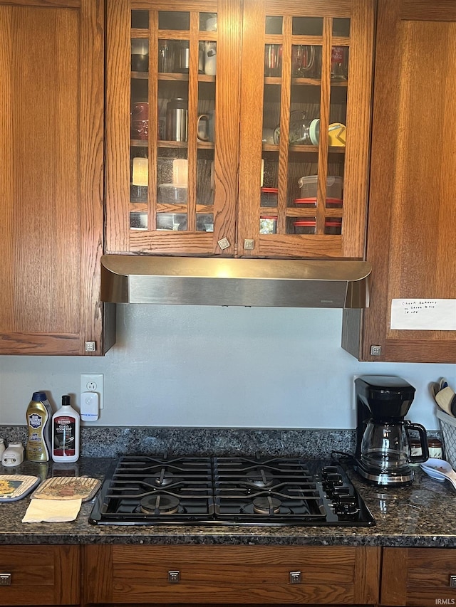 kitchen with black gas stovetop and dark stone countertops