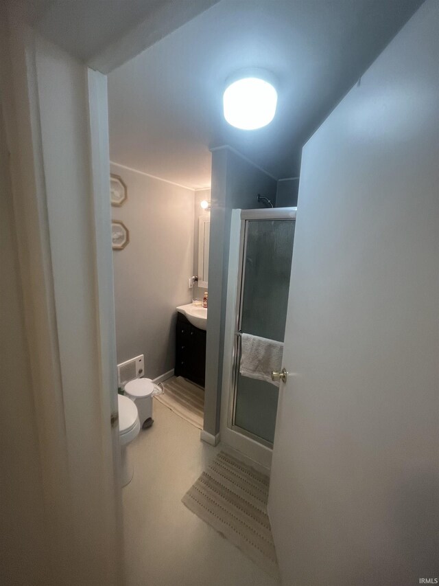 bathroom with a shower with door, vanity, and toilet