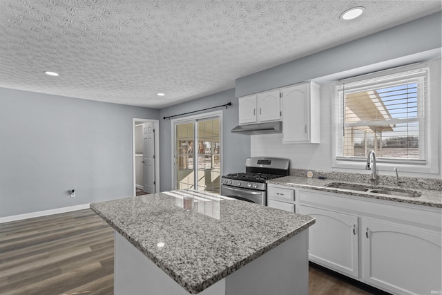 kitchen featuring sink, stainless steel gas range oven, light stone countertops, a textured ceiling, and white cabinets