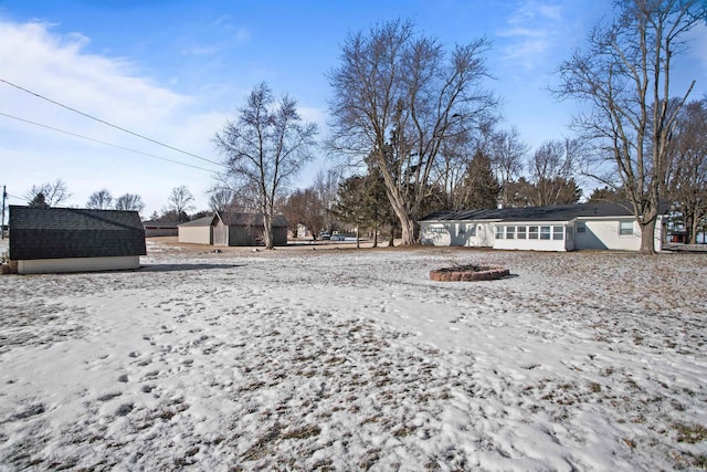 yard layered in snow with a shed