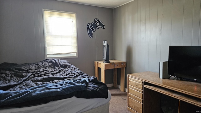 carpeted bedroom featuring multiple windows and wooden walls