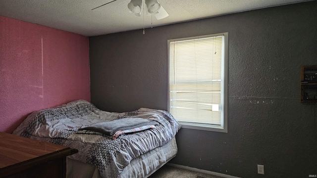 carpeted bedroom featuring a textured ceiling and ceiling fan