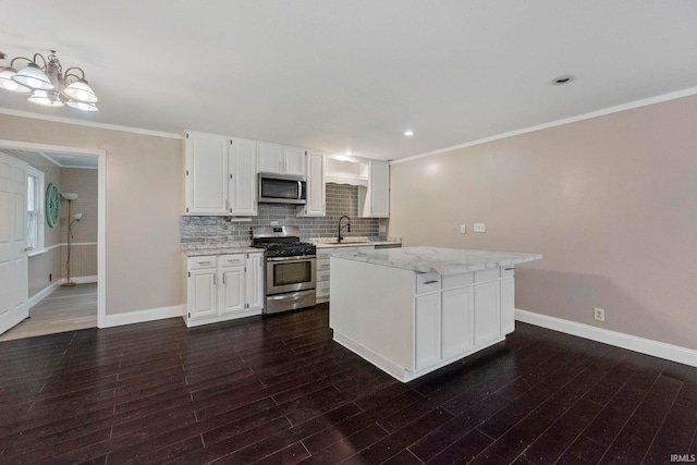 kitchen with light stone counters, sink, white cabinets, and appliances with stainless steel finishes